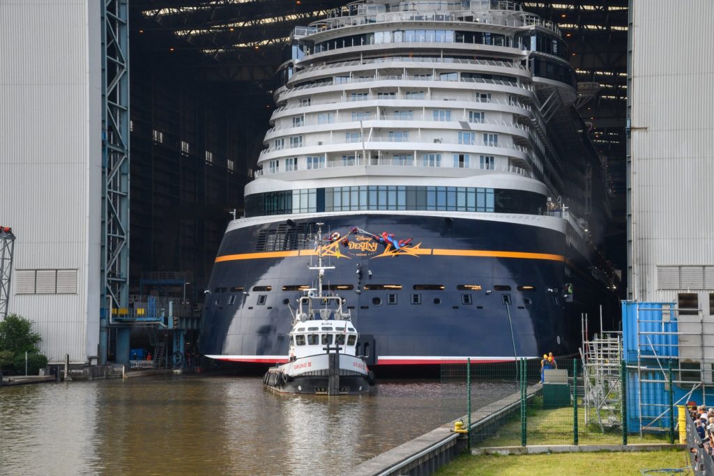 Disney Destiny cruise ship being towed out of shipyard