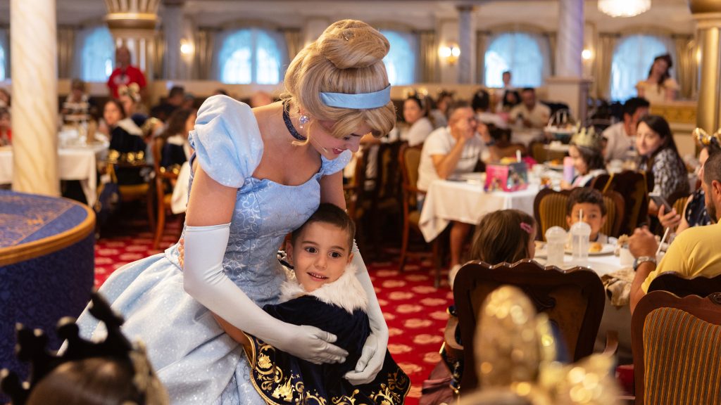 Cinderella hugging a smiling child.