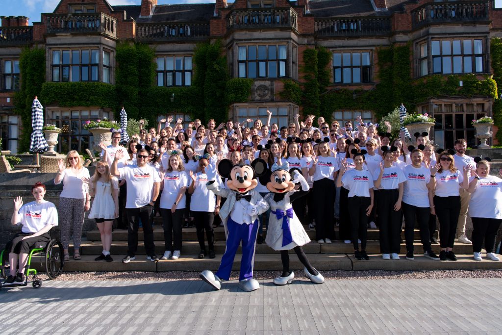 Large group of VoluntEARs with Mickey and Minnie at a Disney Wish event