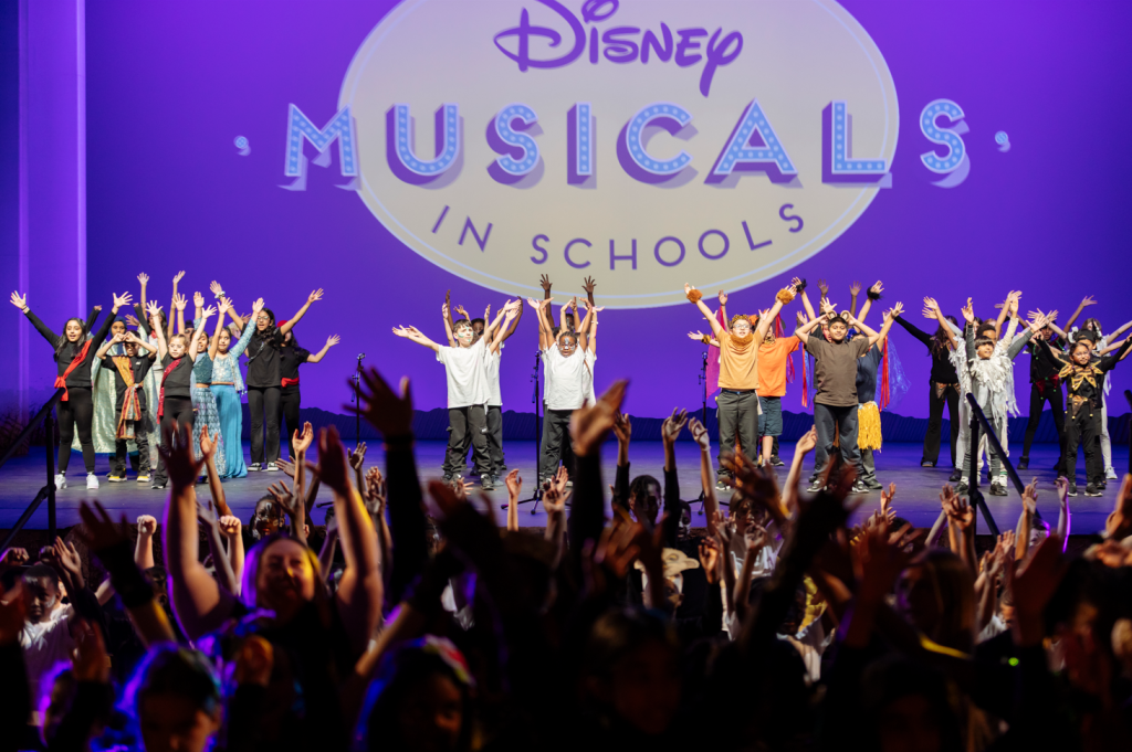 Schoolchildren on stage as part of a Disney Musicals in Schools production