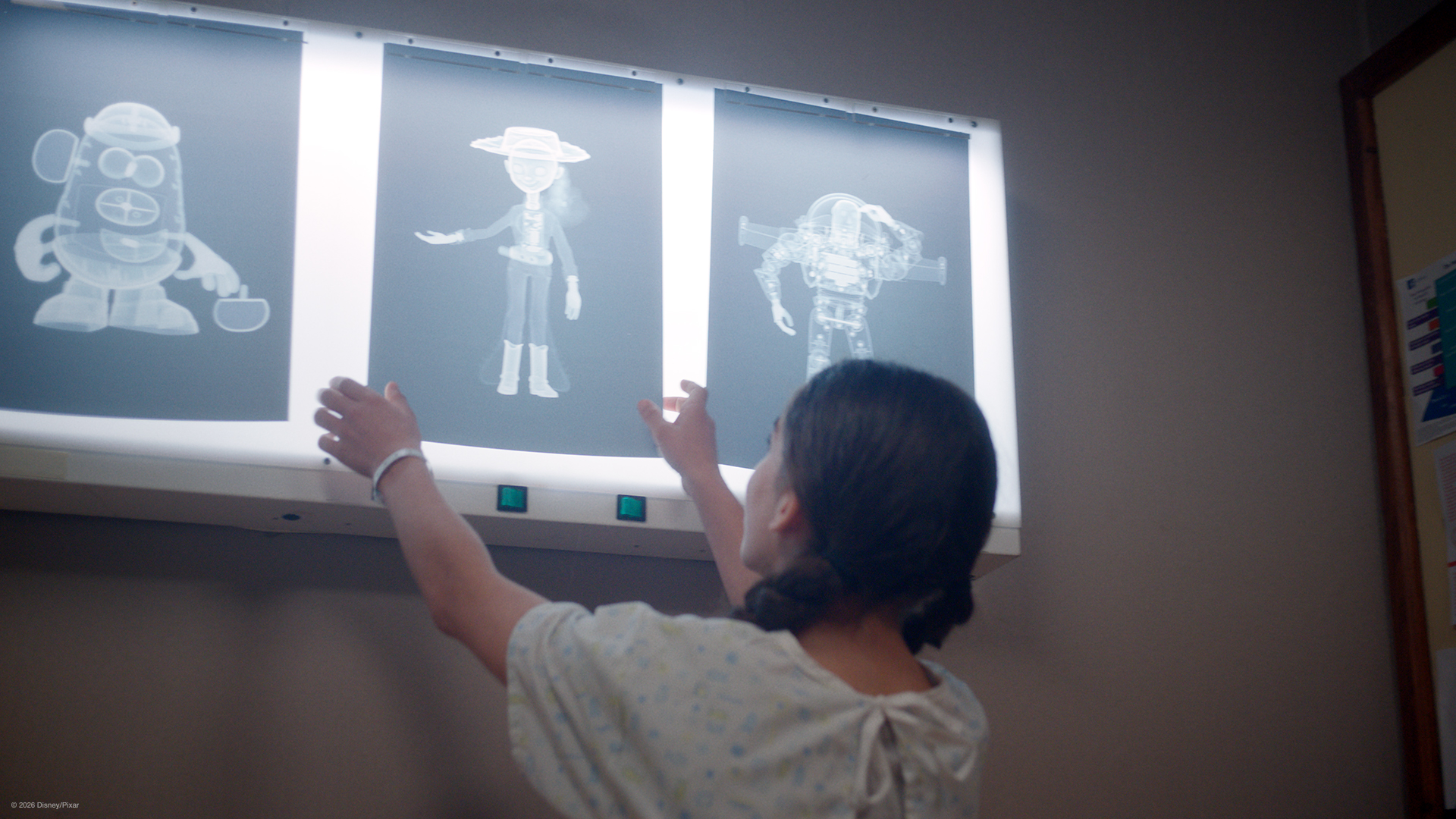 Child looking at xray images of 3 characters from Toy Story 5