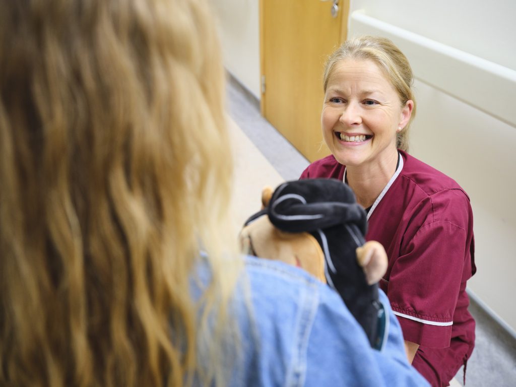Nurse with child holding a Disney toy