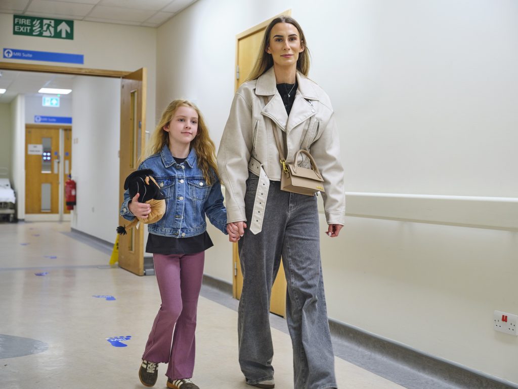 Child with adult in hospital corridor
