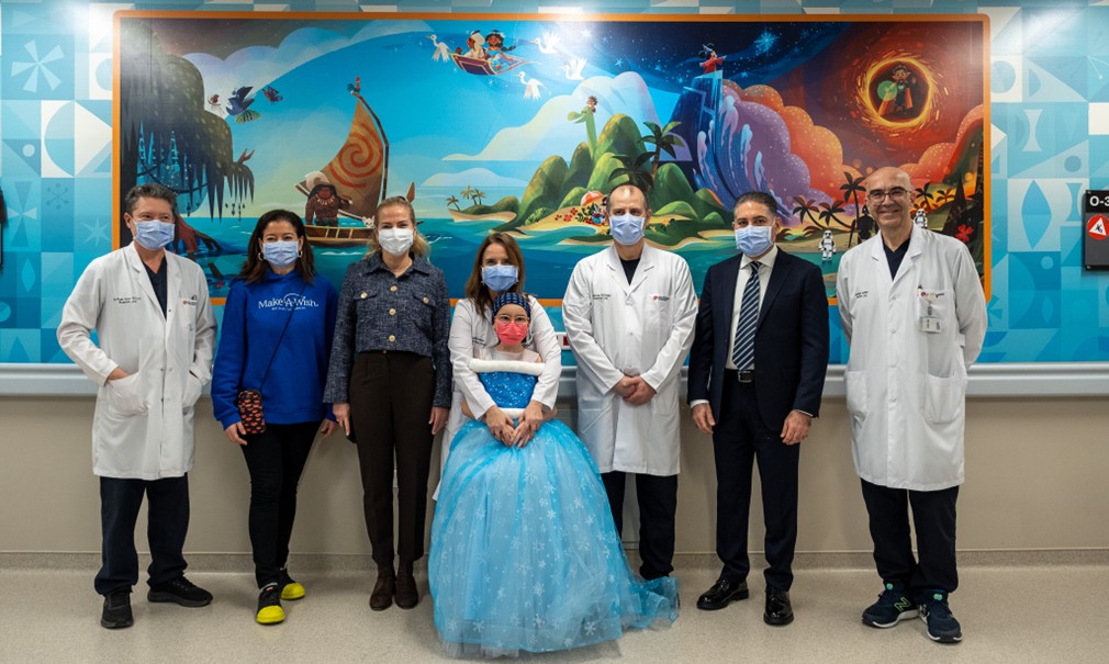 Doctors and patients in front of Disney themed mural at Koç University Hospital in Türkiye