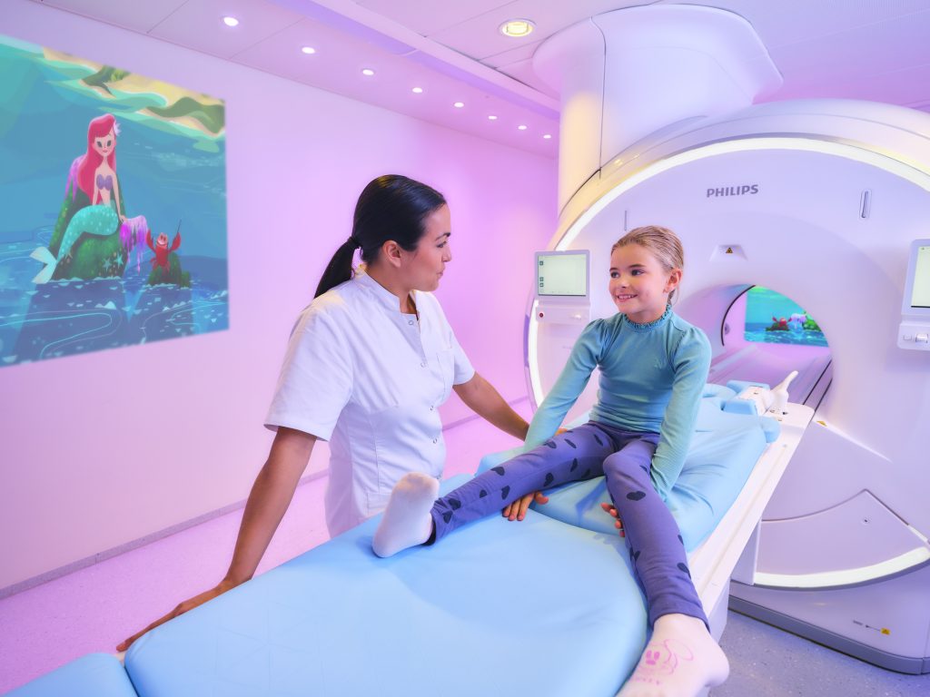 Nurse and patient next to an MRI machine showing the Philips ambient experience for MRI